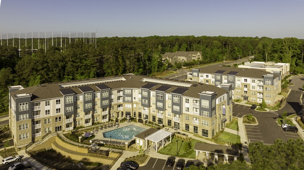 Aerial view of community with apartment building surrounding the community pool