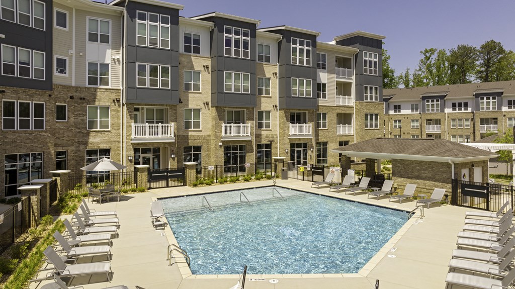 Resort-style pool with chairs, umbrellas and hammocks