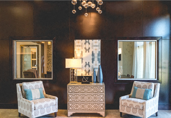 a living room with two chairs and two mirrors