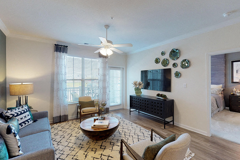 Living room with couch and chair; door to patio or balcony