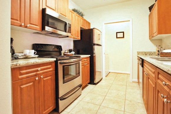 a kitchen with wooden cabinets and stainless steel appliances