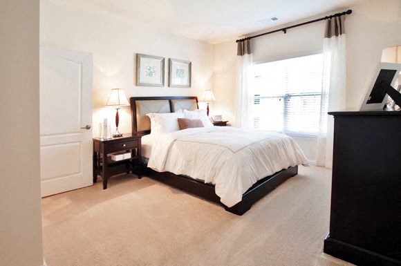 a bedroom with a bed and a dresser and a window