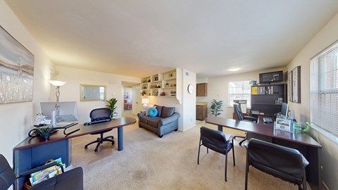 a living area with wall-to-wall carpeting and built-in bookshelves