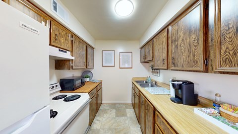 A kitchen with wooden cabinets and a white refrigerator.