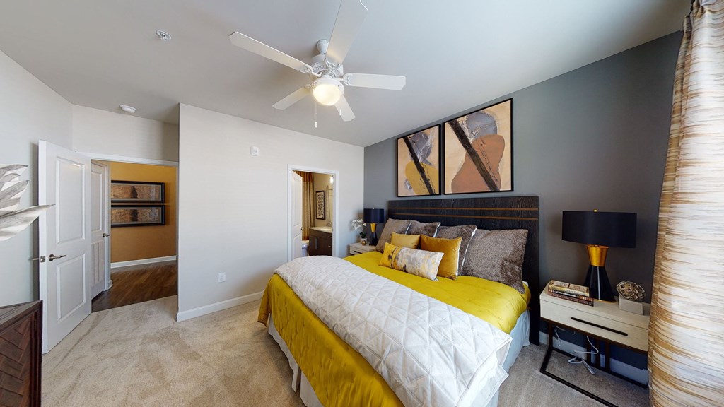 Bedroom with ceiling fan, carpet and door to bathroom