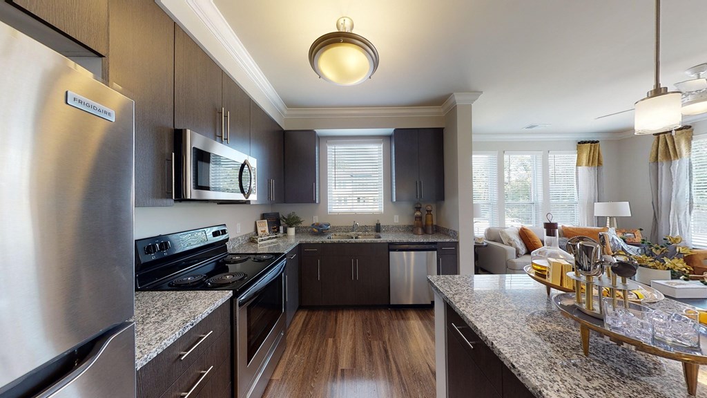 Kitchen with island, dark cabinets, vinyl floors and granite countertops