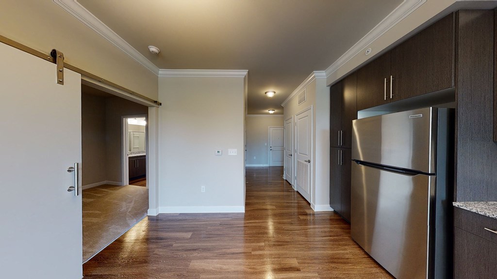 Kitchen with dark cabinets, granite countertops, vinyl wood plank floors