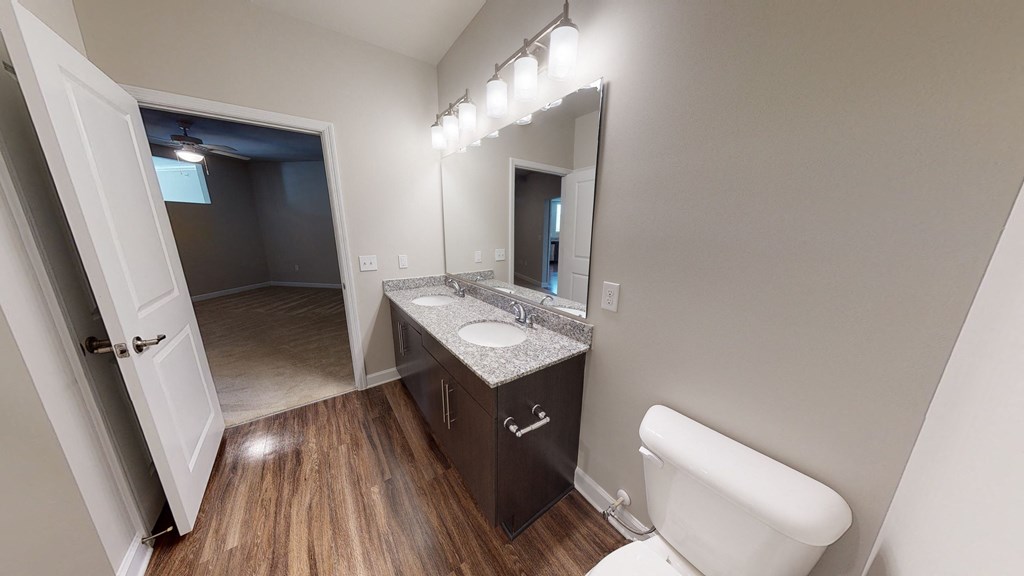 Bathroom with dual sinks and dark cabinets