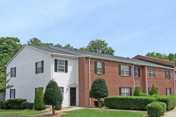 a brick and with a yard and bushes