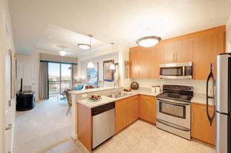 Kitchen with stainless steel appliances; open to living room; sliding door to exterior