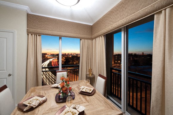 Corner apartment with dining table and chairs; overlooking the city
