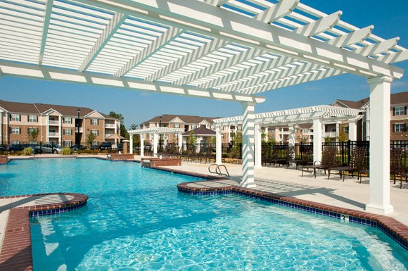 Resort-style pool with pergolas, fountains and chairs