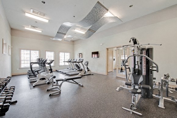 Fitness center with cardio and resistance training equipment; free weights; adjoining playroom