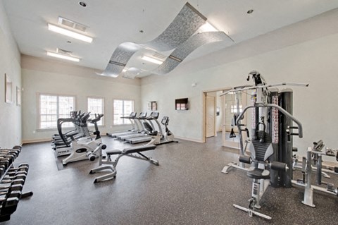Fitness center with cardio and resistance training equipment; free weights; adjoining playroom