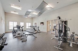 Fitness Center with Adjoining Playroom Fitness center with cardio and resistance training equipment; free weights; adjoining playroom - Photo Gallery