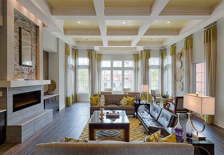 Clubhouse with chairs and fireplace; windows overlooking the pool
