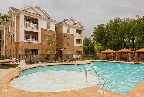 Charlotte, North Carolina, Luxury Apartments with In-Unit Washer and Dryer - Belmont at Tryon - Swimming Pool With Shallow Splash Area, Lounge Chairs, And Cabana Seating.
