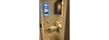 A white toilet and sink in a bathroom.