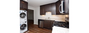 A modern kitchen with dark wood cabinets and a white countertop.
