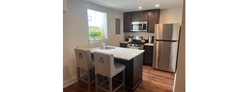 A kitchen with a stove top oven and a refrigerator.
