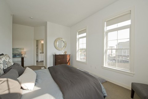 A bedroom with a large bed and a dresser with a mirror.