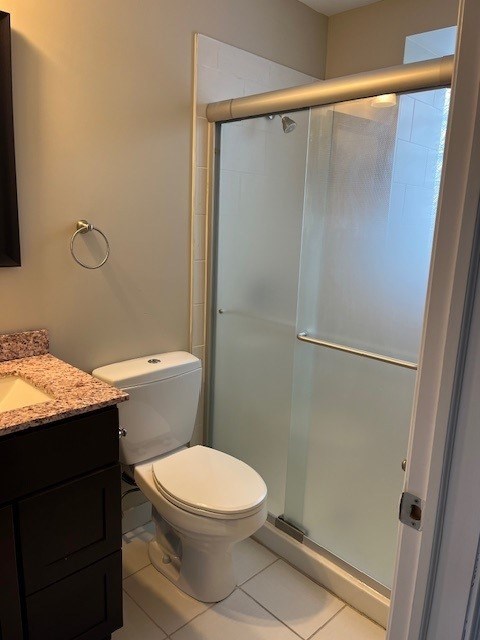 A white toilet sits in a bathroom next to a walk-in shower.