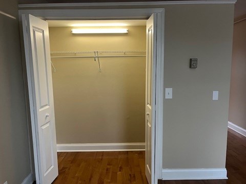 A small white closet with a light on.
