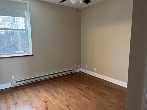 A room with wooden flooring and a window.
