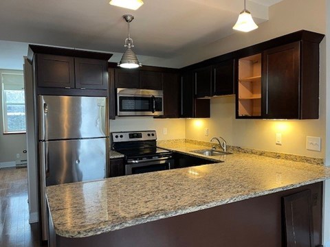 A kitchen with a granite countertop and stainless steel appliances.