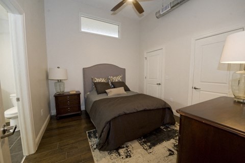 A bedroom with a bed, nightstands, and a ceiling fan.