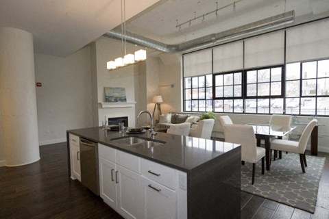 A modern kitchen with white cabinets and a black countertop.