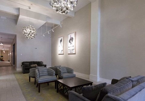 A living room with grey couches and a chandelier.
