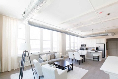 a living room with a couch and a table and a kitchen