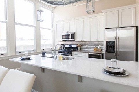 A kitchen with white cabinets and a white countertop.