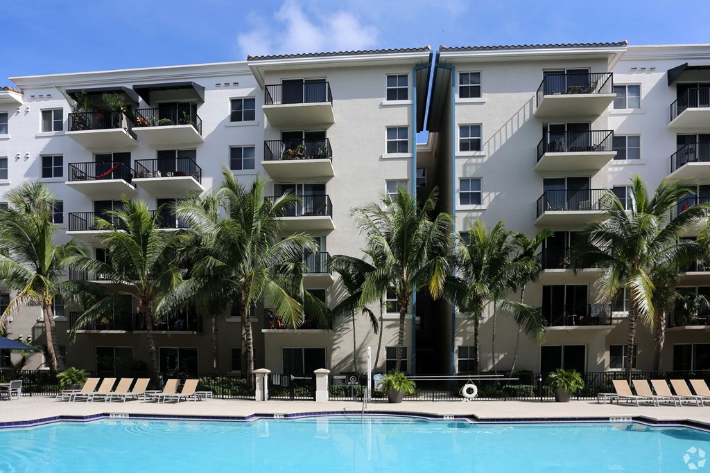 An apartment building with a pool in front of it.