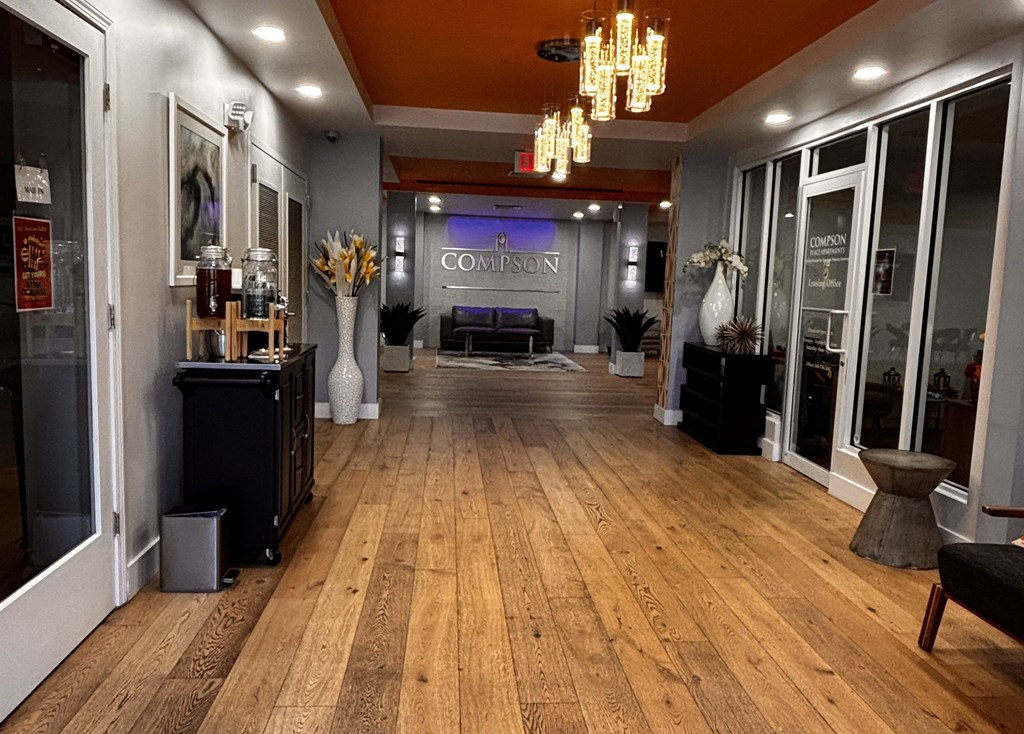 A long hallway with a wooden floor and a sofa.