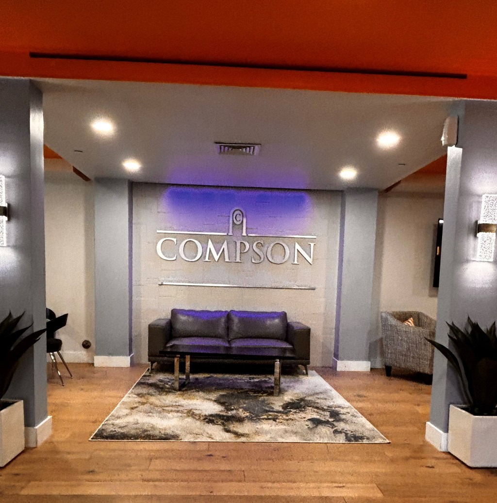 A Compson logo is displayed on a wall above a couch.