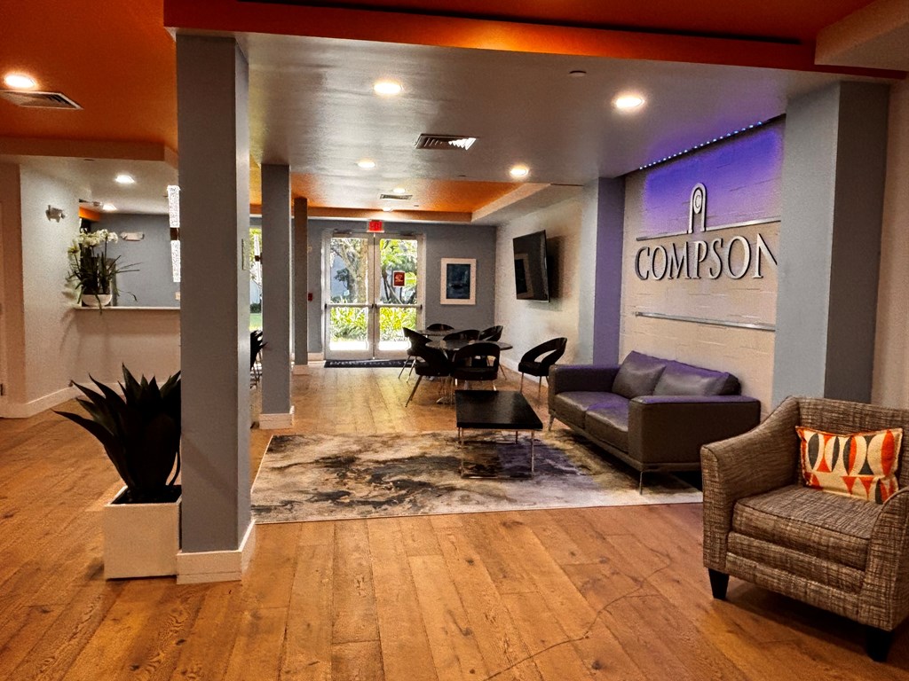 A lobby with a leather couch and a sign reading “Compson”.