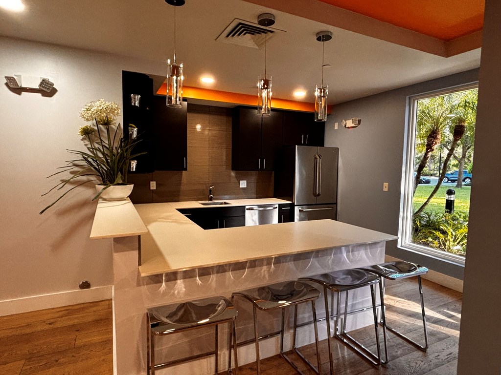 A kitchen area with a white counter top and black cabinets.