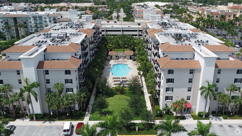 A large apartment complex with a pool in the middle.