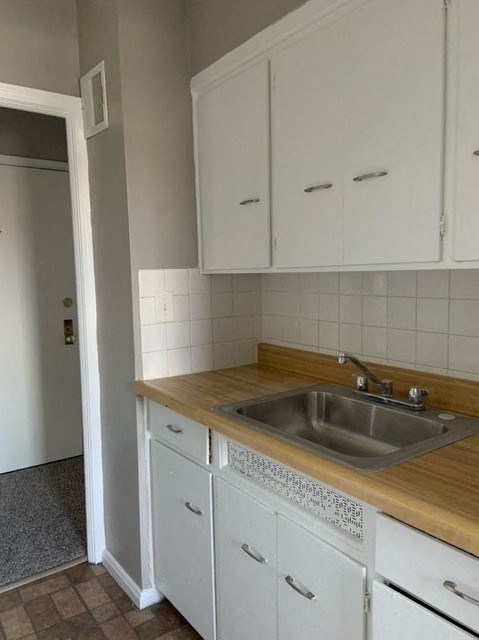 a kitchen with a sink and white cabinets