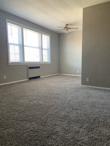 an empty room with a ceiling fan and a window