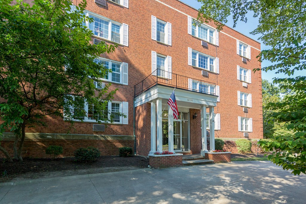 the front of a brick building with an flag on the side