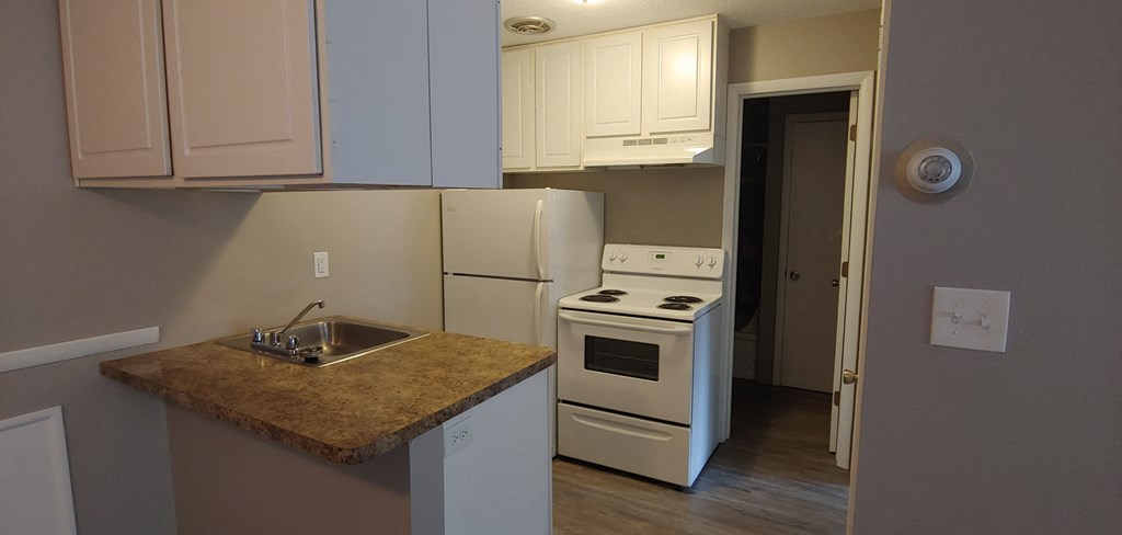 a kitchen with white appliances and a granite counter top