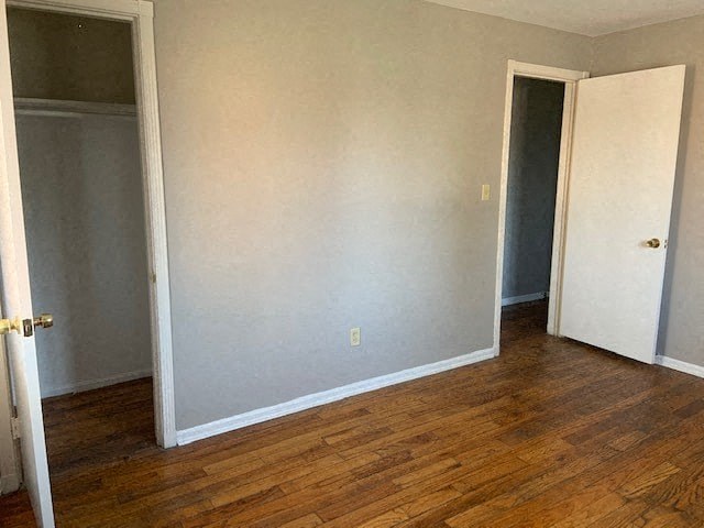 an empty room with a wooden floor and a door