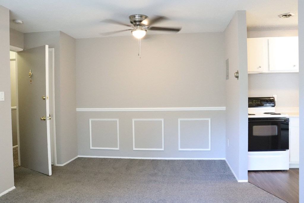 an empty room with white walls and a ceiling fan