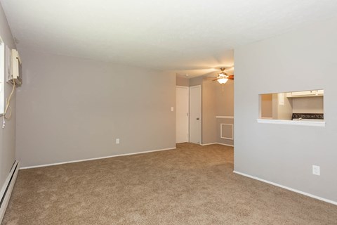 a spacious living room with carpeted flooring and a fireplace
