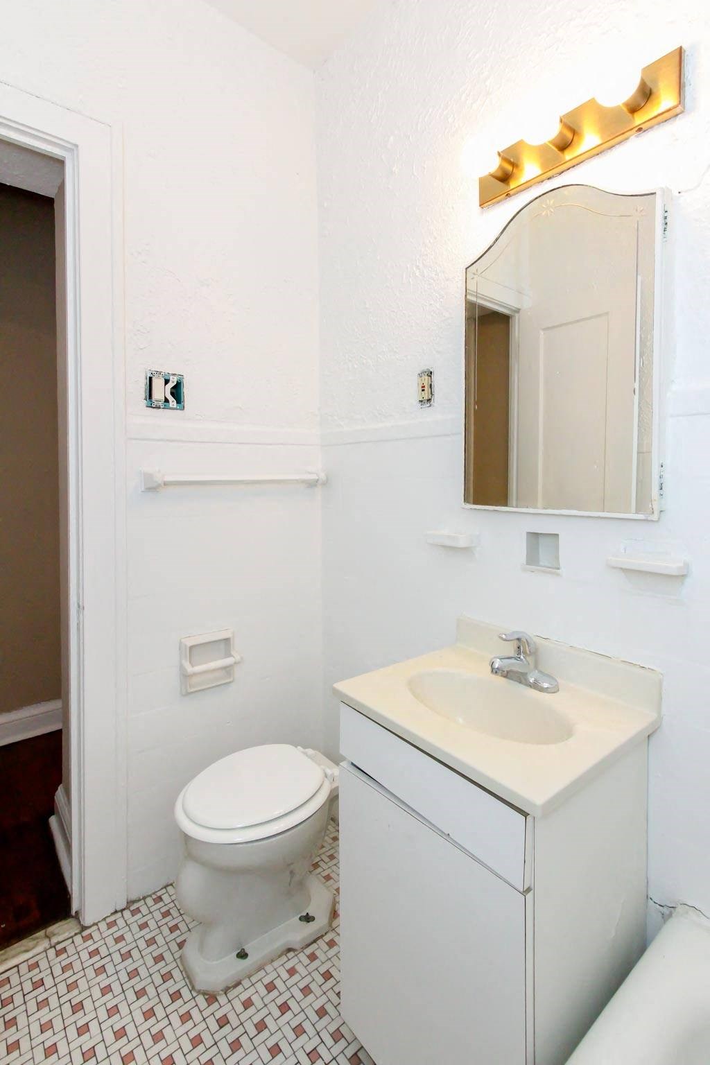 a bathroom with a toilet and a sink and a mirror
