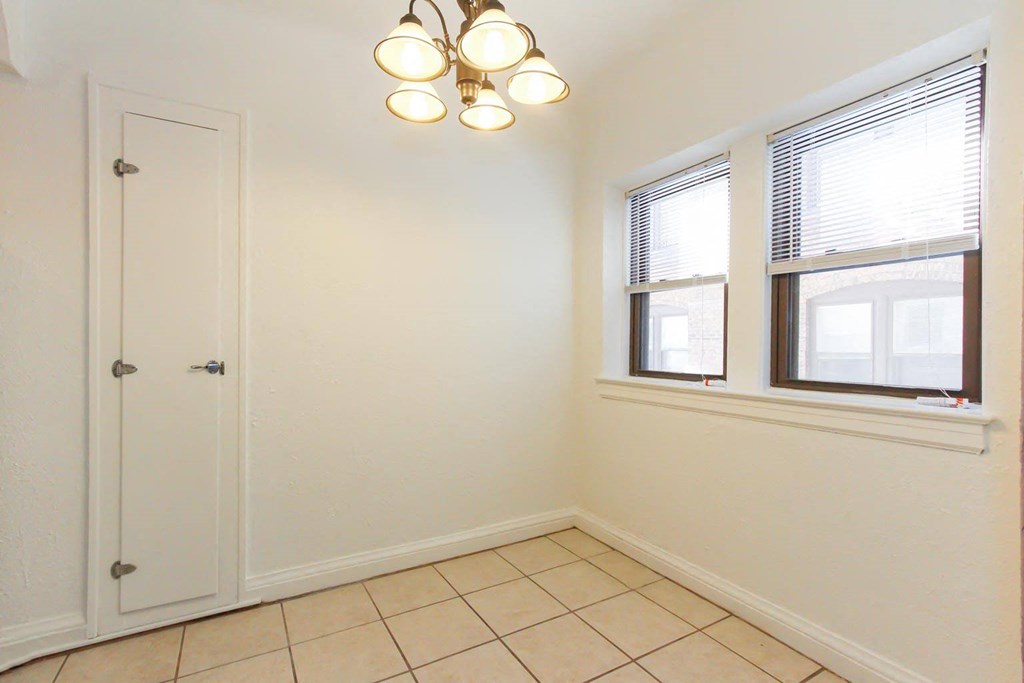 a bedroom with two windows and a door and a tiled floor