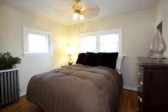 a bedroom with a large bed and a ceiling fan
